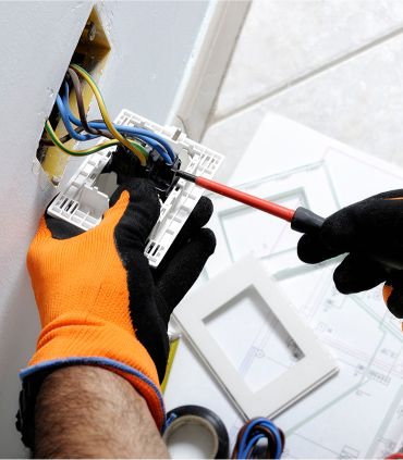 electrician fixing a plug socket